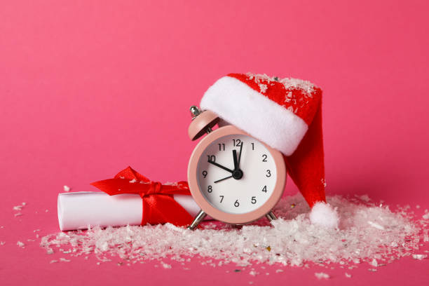 istock A clock with a Santa hat with a New Year's decoration. 2170187333