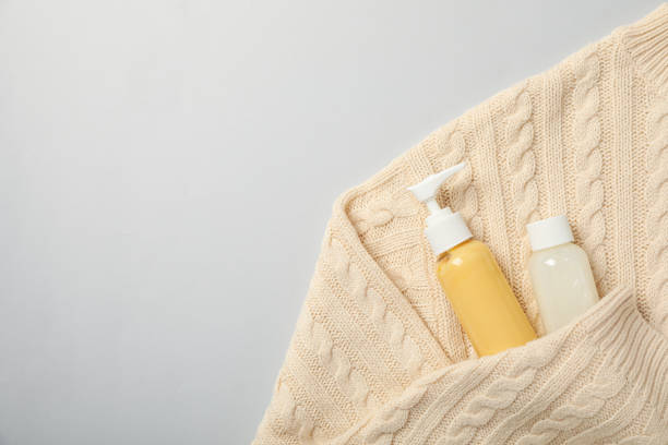 istock Cosmetic bottles in sweater on white background, space for text 2170191712
