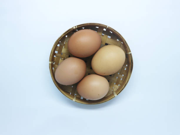istock A top-down view of a small wicker basket containing four brown eggs placed on a clean white background. 2170191721