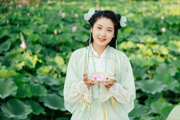 A Hanfu beauty playing outdoors by the lotus pond in summer