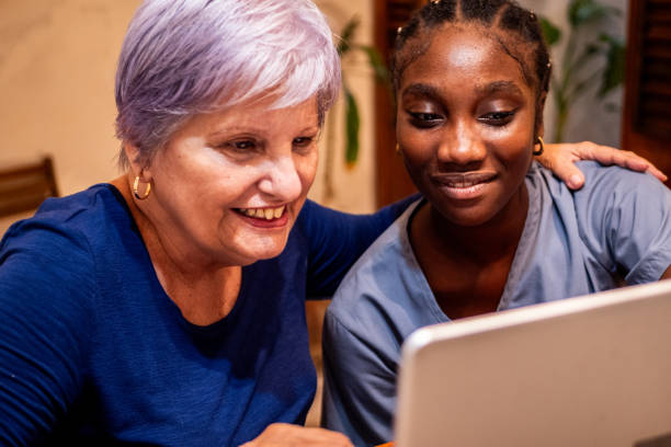 istock Female nurse and senior woman using computer at home 2170194354