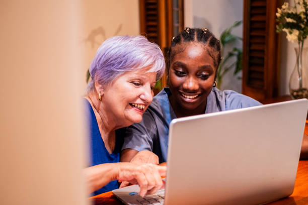 istock Female nurse and senior woman using computer at home 2170194359