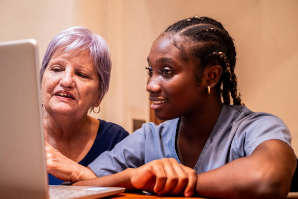 istock Female nurse and senior woman using computer at home 2170194371