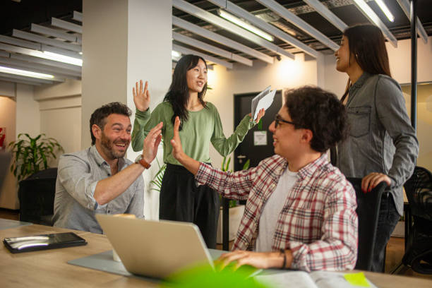 istock Members of project group high-five after completing company assignment successfully 2170195432