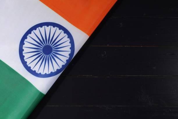 istock Indian national flag displayed on a wooden surface showcasing vibrant saffron, white, and green colors along with the Ashoka Chakra design 2170201431