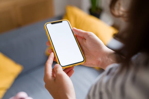 istock Woman holding smartphone with empty white screen at home 2170201849