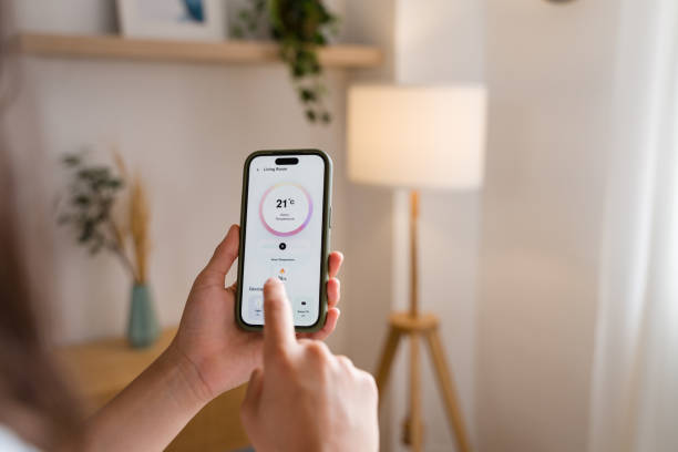 istock Woman controlling home temperature with smart home application on smartphone 2170201856