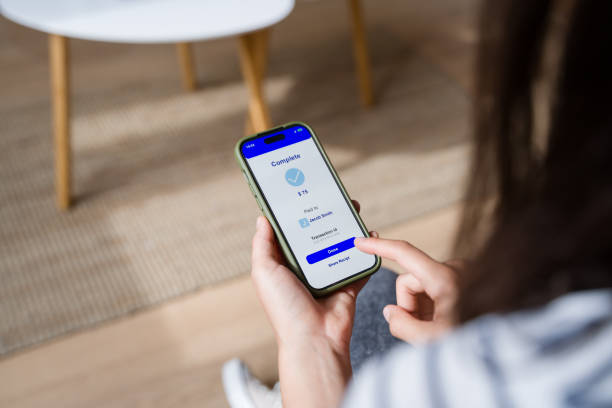 istock Woman completing online mobile payment on smartphone app at home 2170202536