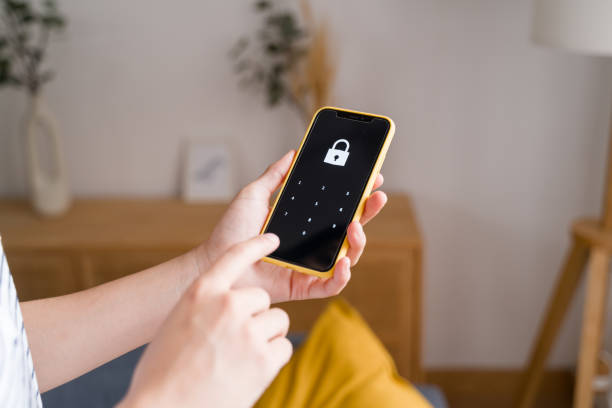 istock Woman holding smartphone and entering password on screen 2170202591