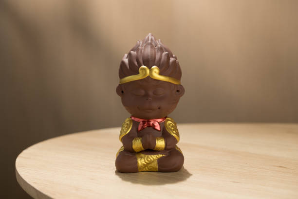 Cute ceramic doll of Sun Wukong found meditating; intricate gold details highlight cultural artistry.
