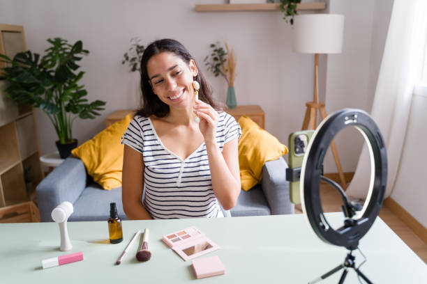 istock Beauty influencer applying jade roller on face during livestreaming 2170203339