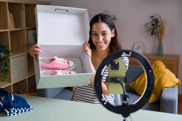istock Smiling influencer showing new pink sneakers from delivery box 2170203683