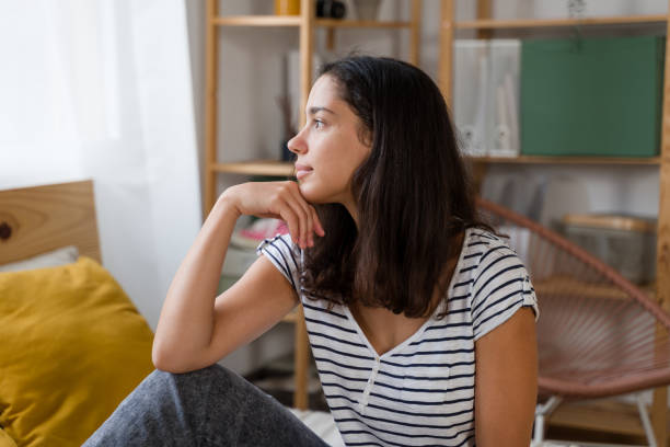 istock Young woman is sitting on bed and thinking about something 2170204625