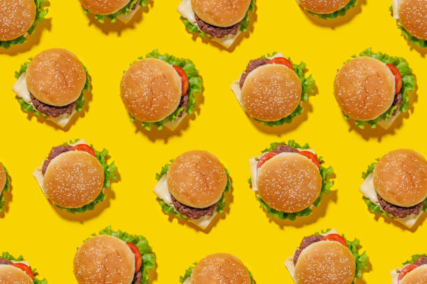 istock Seamless, lively pattern featuring hamburgers spread evenly across a bright yellow background 2170204955