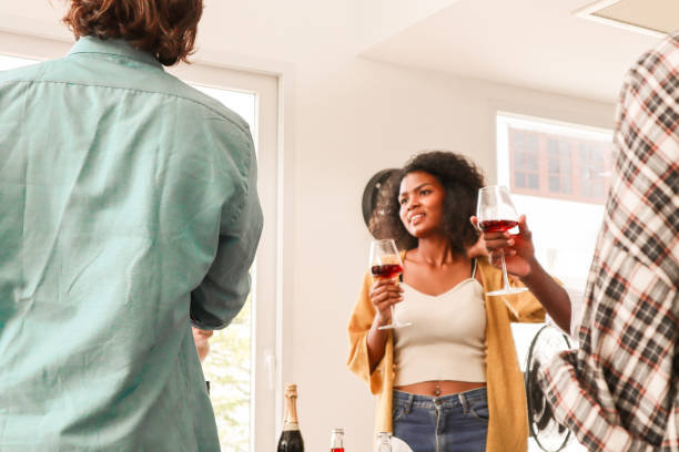 istock A young woman joyfully talking with multiracial friends at a dining table, smiling as they enjoy champagne in a warm and loving toast, sharing a moment of togetherness and celebration. 2170205252