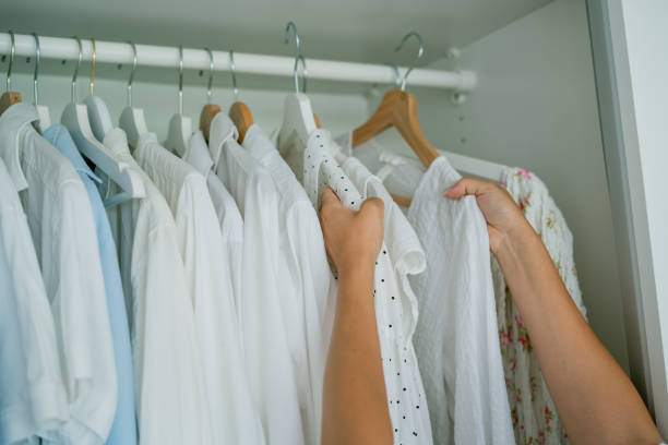 istock Young dark-haired curly beautiful woman is sorting things in large spacious closet. Home organization. Washing things. Analysis of clothes by season. 2170207829