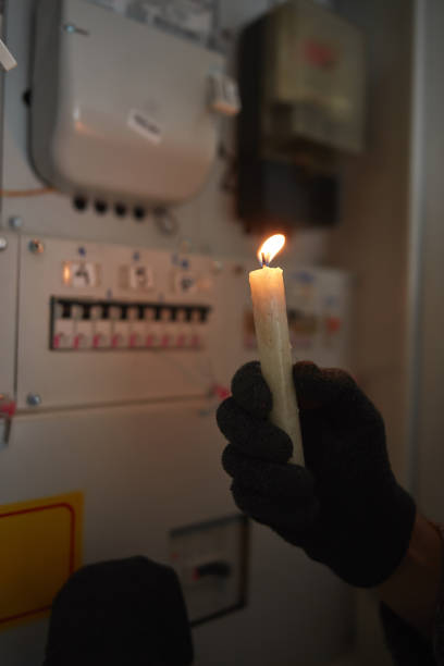istock Checking the electricity power meter with a candle in cold winter days while there is power outage. 2170208765