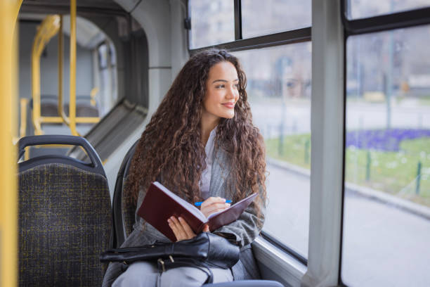 istock Happy girl smiling when riding the bus and reading her notes 2170209693