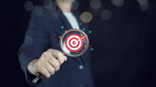 istock Man hold Target board inside of magnifier glass for focus business objective achievement concept. Search, goal, strategy, success. 2170210002
