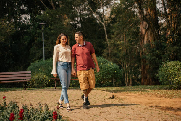 istock Couple walking in park, man with prosthetic leg 2170210073