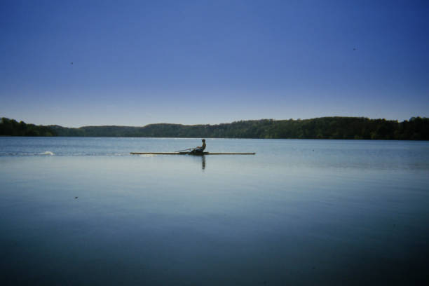 Cambridge, Massachusetts, USA -  May 22, 2024: Close-up of a woman rower in a single sculling boat on the Charles River.