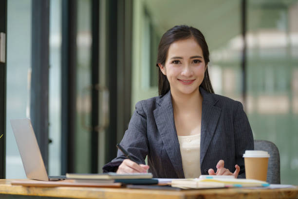istock Confident young businesswoman looking at the camera while sitting at her workspace. 2170211699