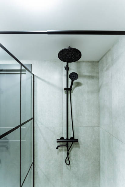 istock The image shows a black shower head suspended from the ceiling in a shower. It is likely a part of an interior design project, focusing on plumbing fixtures and monochrome photography 2170223195