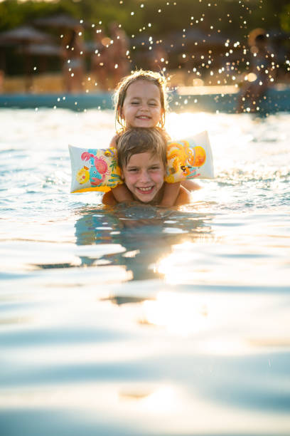 istock Siblings playing in the swimming pool 2170223290