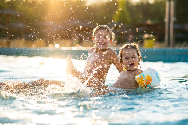 istock Children having fun splashing whit water in swimming pool 2170226580