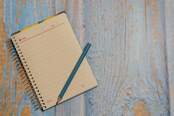 Recycled paper notebook open on a clean sheet on a board with a pencil
