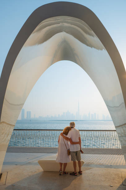 istock Embracing couple under modern arch with skyline view of Dubai 2170233704