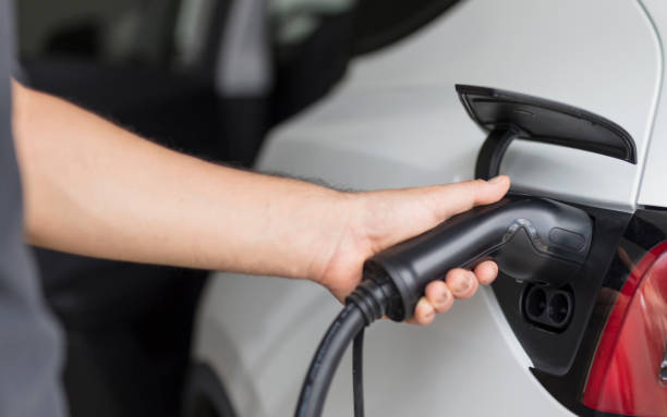 istock Man plugged cable charging an electric car at home 2170234769