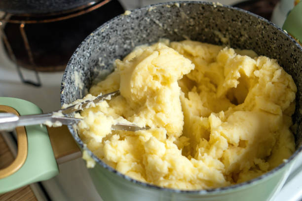 istock nostalgic kitchen scene featuring a pot of creamy mashed potatoes, accompanied by a perforated metal masher, evokes warmth and comfort celebration of homemade meals 2170235224