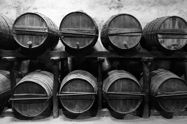 istock Barrels for whiskey or wine stacked in the cellar in black and white 2170237040
