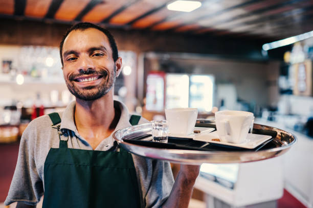 istock Waiter serving group of friends in a cafe 2170241646
