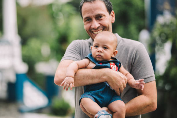 istock Smiling dad holding his son in the nature 2170241702