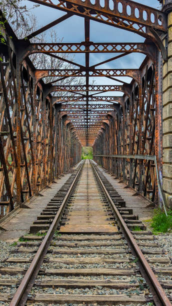 istock Vertical picture of abandoned and rusty railway track in a bridge with iron structure, in autumn at Occitanie, France 2170244490