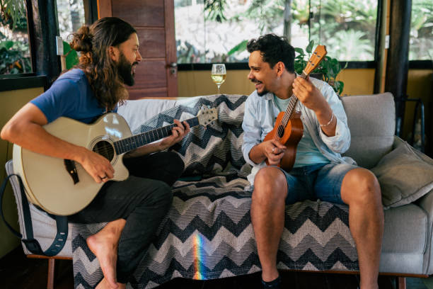 istock Two young men playing guitar together at home 2170245337