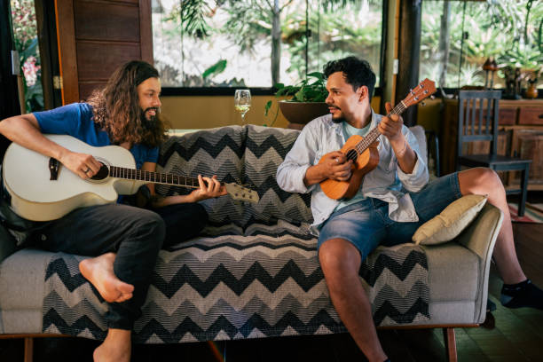 istock Two young men playing guitar together at home 2170245341