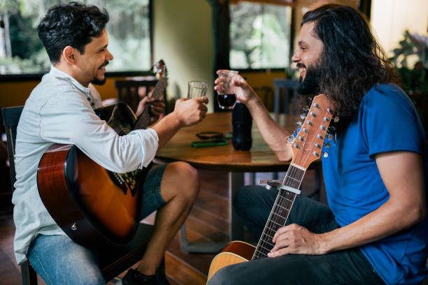 Two young men spending time together and playing guitar in the living room