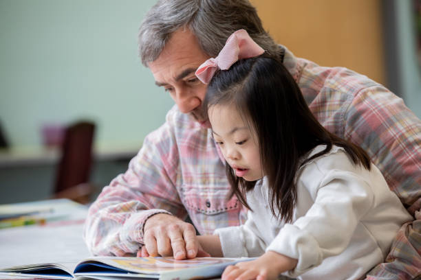 istock Adoptive father reads book to young daughter with Down Syndrome 2170251281