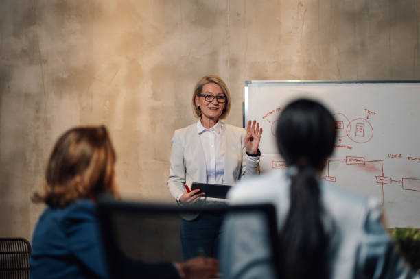 istock Mature woman team leader presenting sales reports on a whiteboard 2170252251