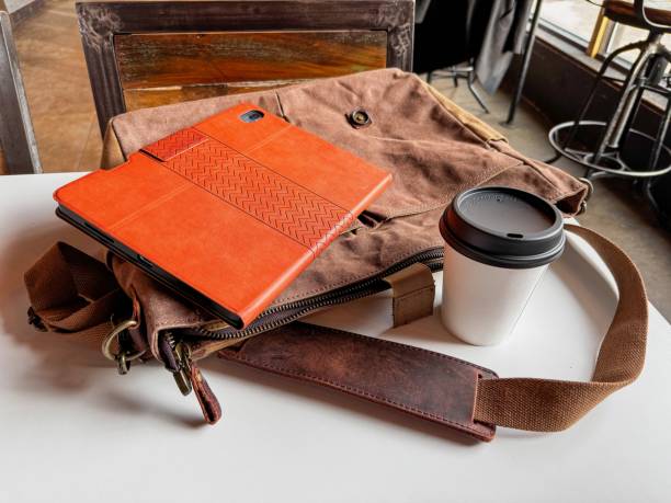 istock Tablet, Coffee, and Messenger Bag on the Table at a Coffee Shop 2170258690