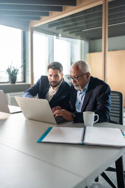 istock Diverse Senior Executive with Young Intern Collaborating in Office 2170259190