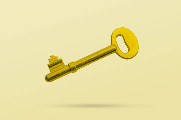 istock Old golden house key isolated on yellow background 2170259214