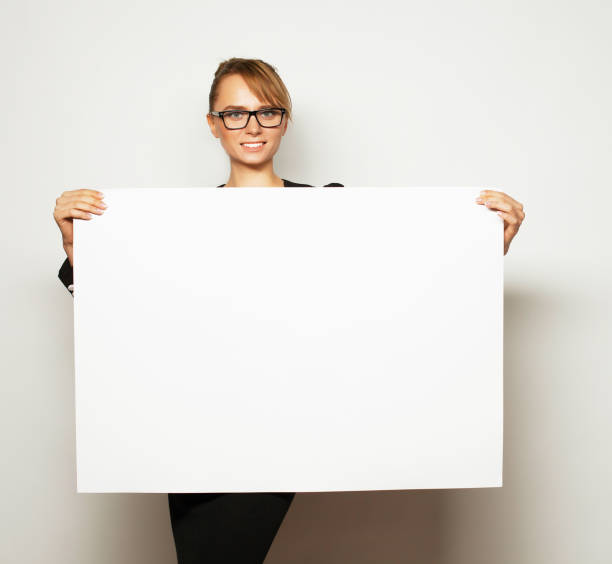 istock business woman holding a blank billboard. 2170262293