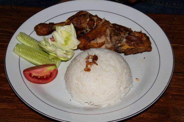 istock Fried chicken with vegetables and rice on a plate, typical Indonesian food 2170263242