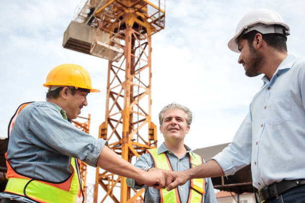 istock Team of workers at construction site with heavy machines. 2170265814