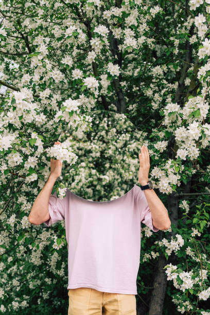 Creative male portrait with mirror in blooming apples spring garden