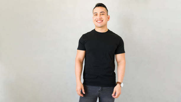 istock Young man in black t-shirt smiling against grey background, ideal for your design project 2170270468